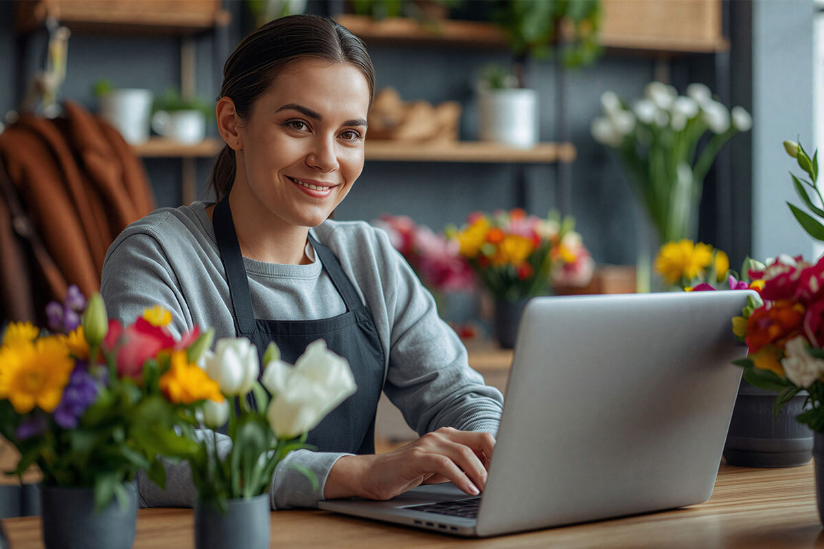 A young florist checking updates on the laptop