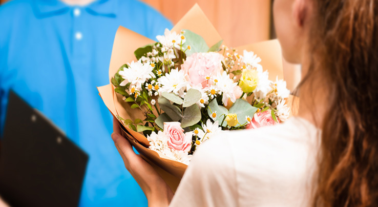 A delivery guy delivered a bouquet of flowers to a lady/woman