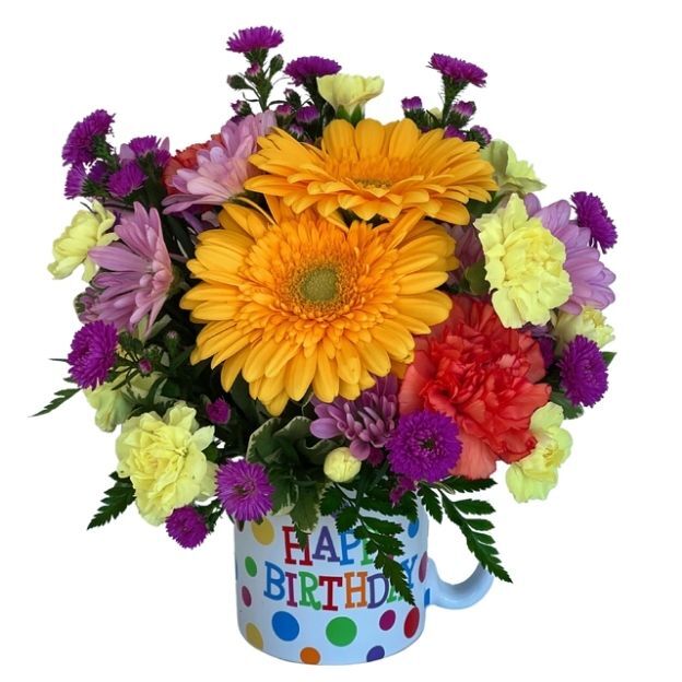 Bright birthday flower arrangement with yellow gerbera daisies, colorful blooms, and greenery in a Happy Birthday mug.